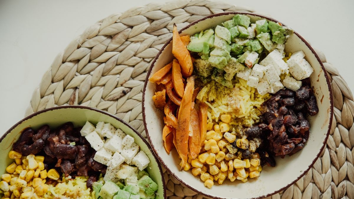 Top view of vegetarian bowls with avocado, corn, beans, and cheese for a delicious meal.